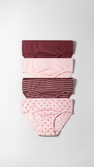 Set of four girl's underwear with different patterns on a light gray background