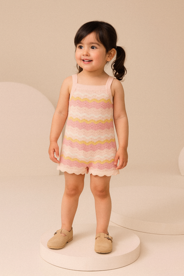 Young girl wearing a pink and yellow striped dress on a beige background