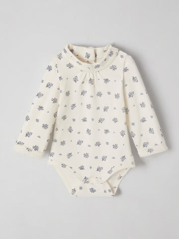 White baby onesie with floral pattern on a light gray background