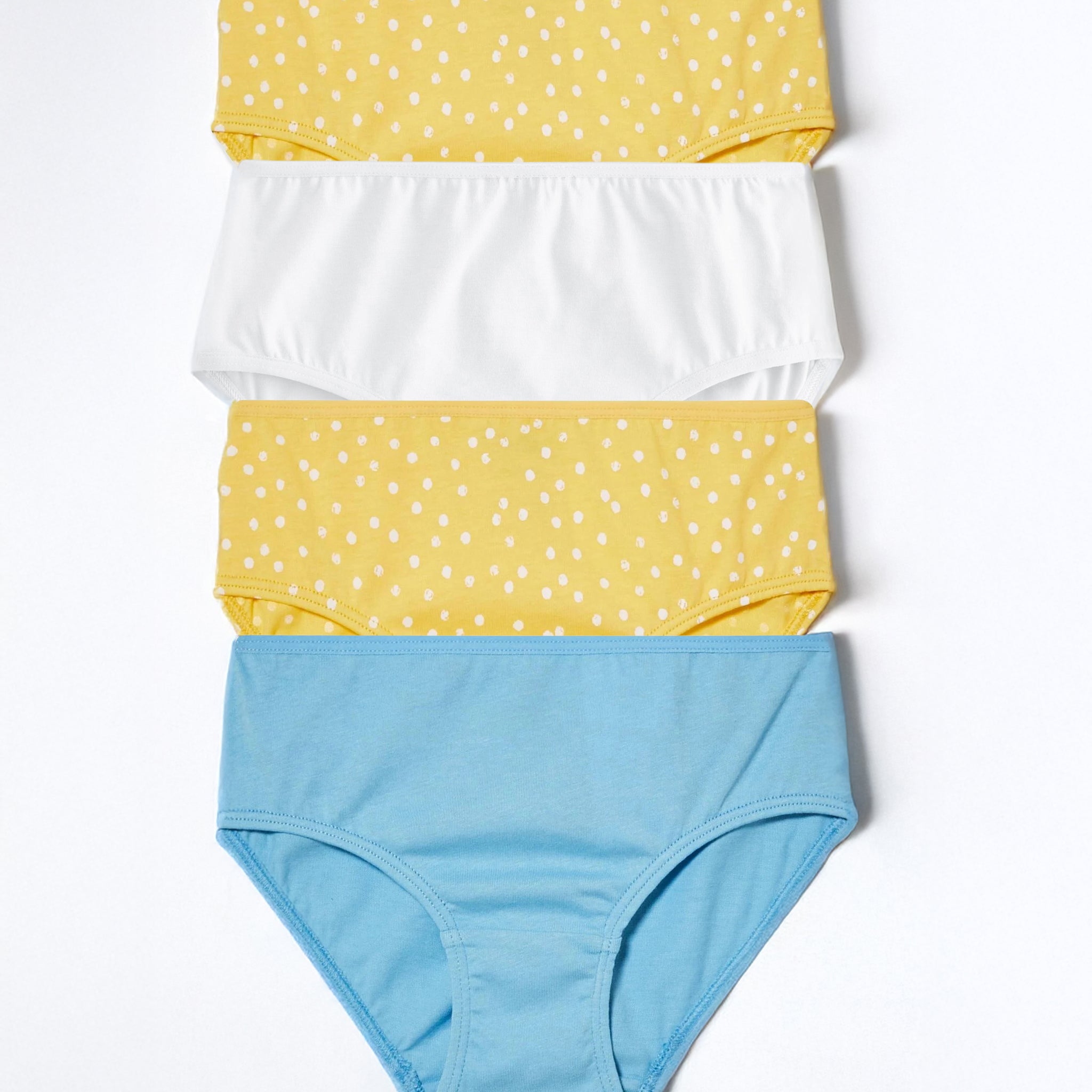 Set of four pairs of girl's underwear in yellow with white polka dots and blue on a white background