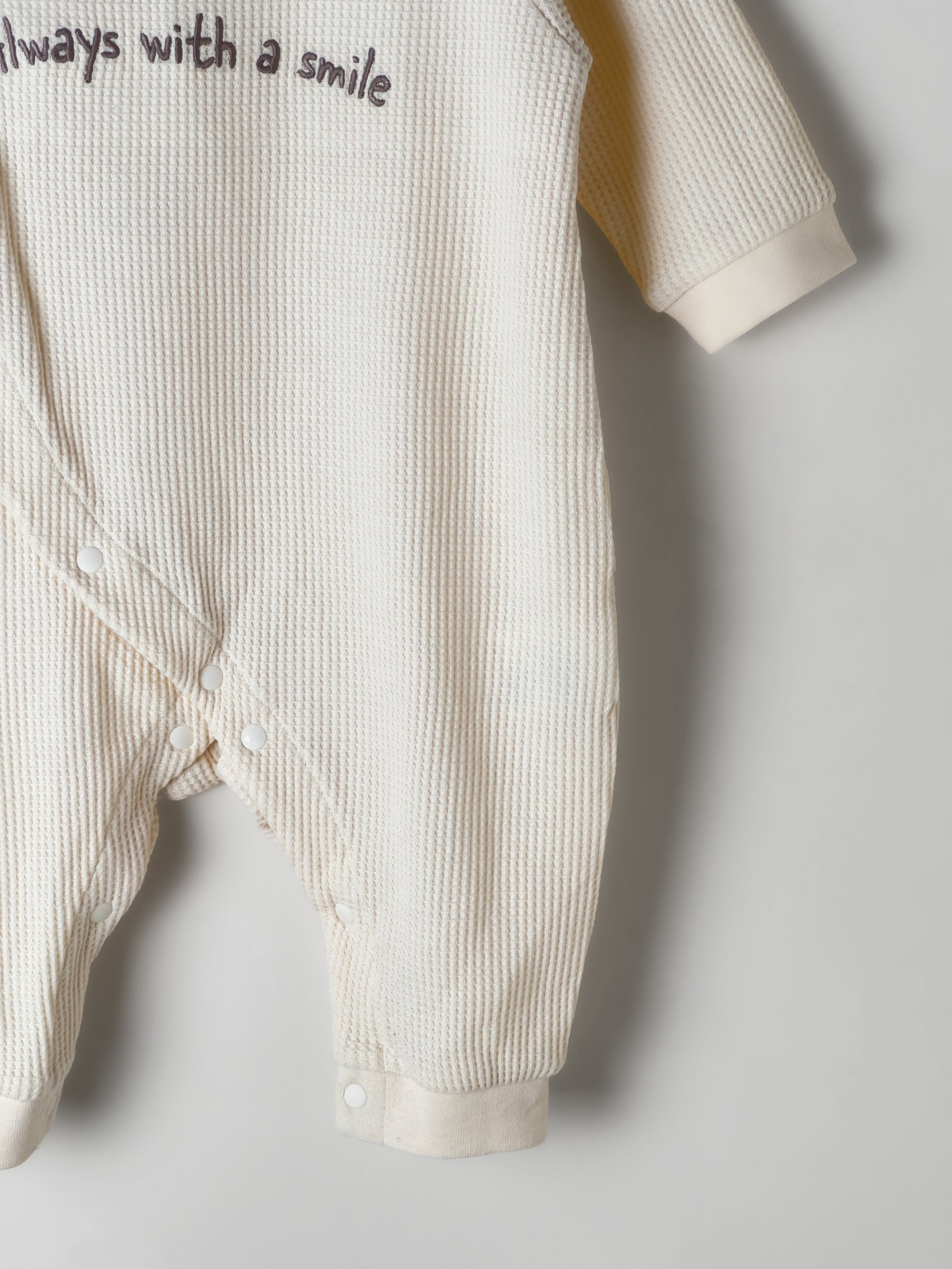 Baby Romper in beige color with a waffle fabric pattern