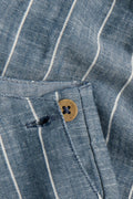 Close-up of PTex Fashion striped chambray dungaree fabric and wooden button detail