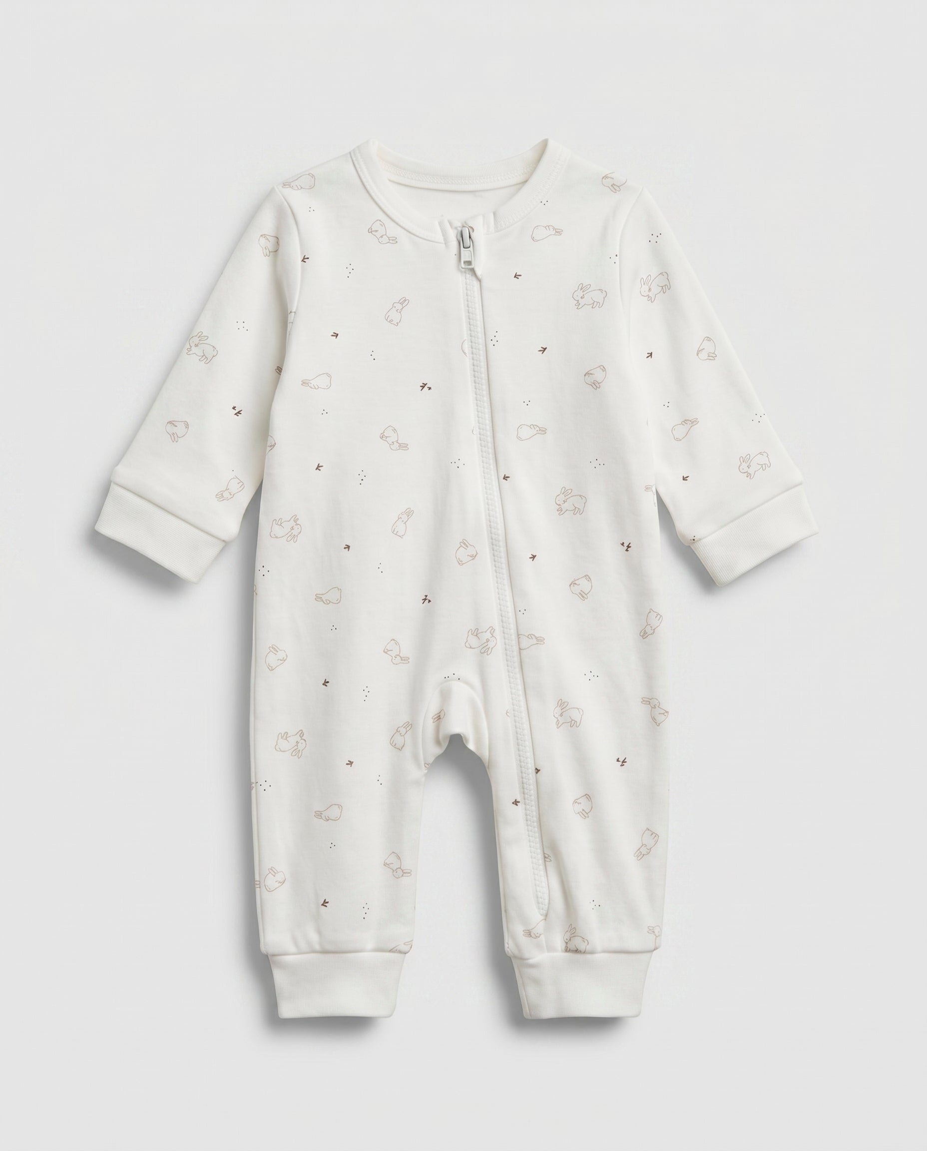 Ivory baby long-sleeve zip-up romper with all-over scattered bunny and bird print in taupe, featuring front zip closure with inner guard flap and ribbed cuffs at wrists and ankles