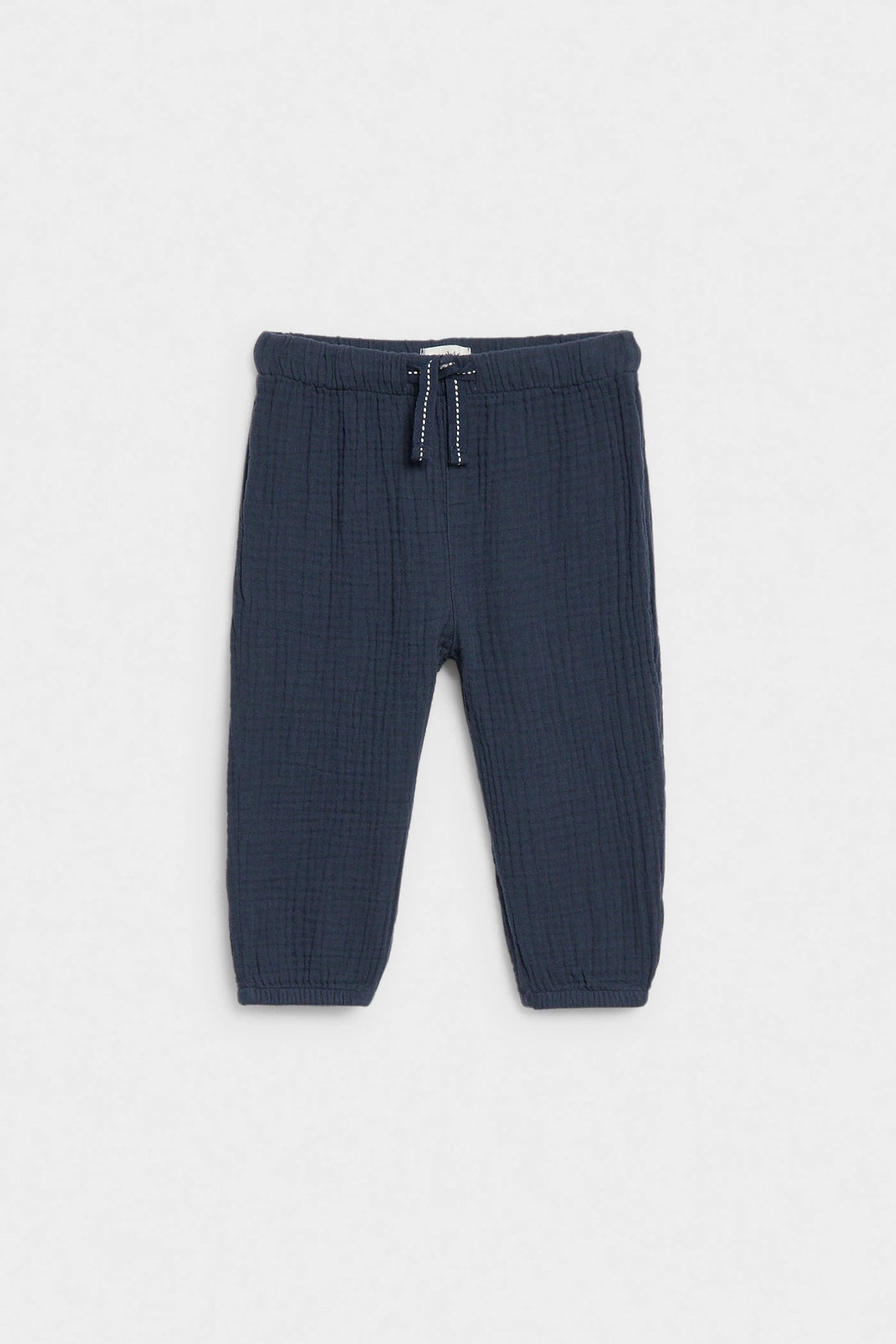 Navy blue baby muslin trousers with drawstring waist and elasticated ankle cuffs, flat lay — PTex Fashion