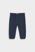 Navy blue baby muslin trousers with drawstring waist and elasticated ankle cuffs, flat lay — PTex Fashion