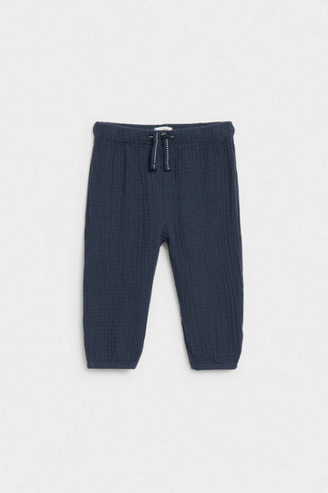 Navy blue baby muslin trousers with drawstring waist and elasticated ankle cuffs, flat lay — PTex Fashion
