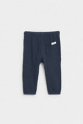 Back view of navy blue baby muslin trousers showing patch pocket and elasticated waist — PTex Fashion