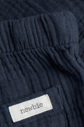 Close-up of elasticated waist and back patch pocket on navy blue baby muslin trousers — PTex Fashion