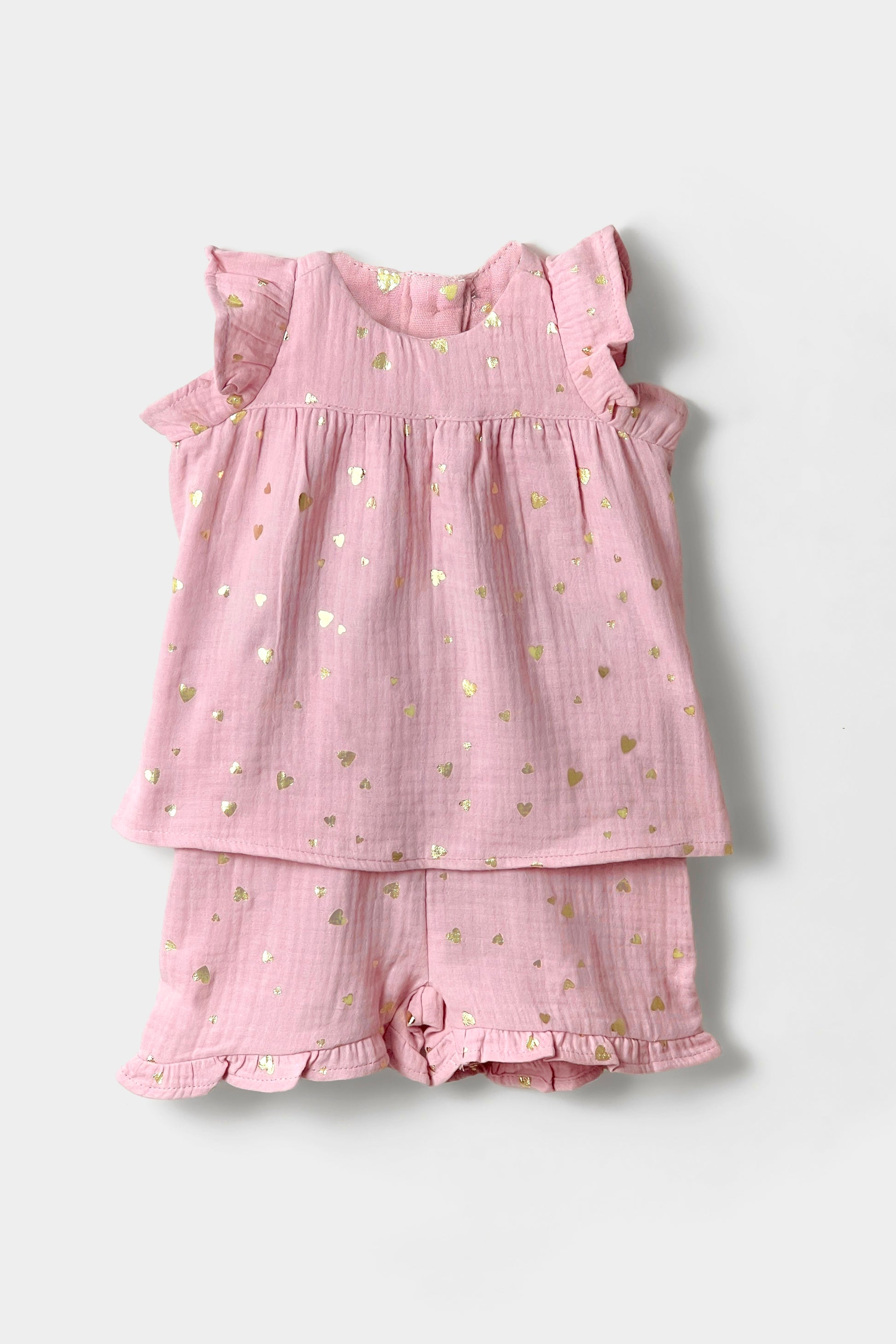 Pink children's outfit with ruffled top and shorts on a light gray background