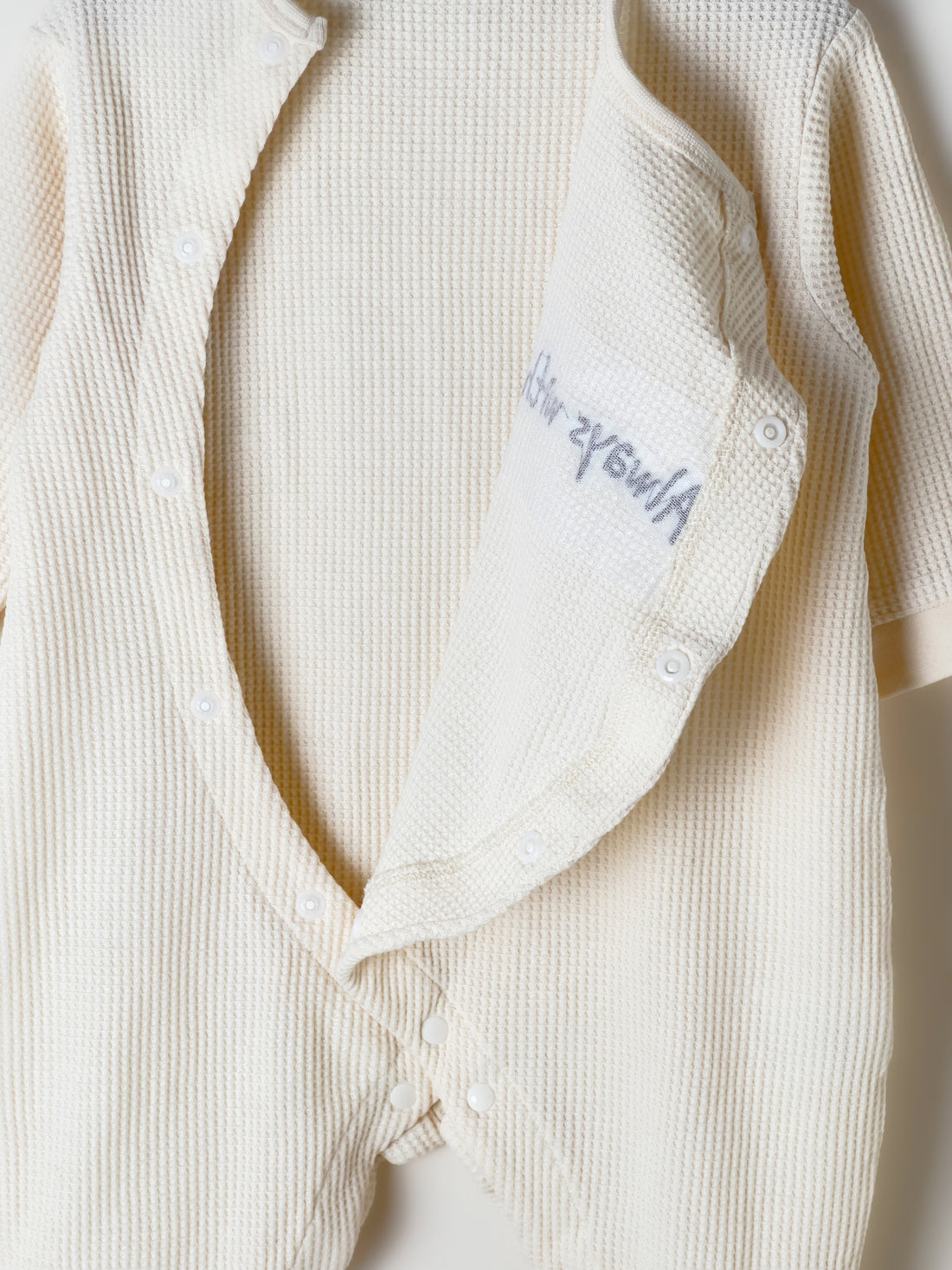 Baby Romper in beige color with a waffle fabric pattern
