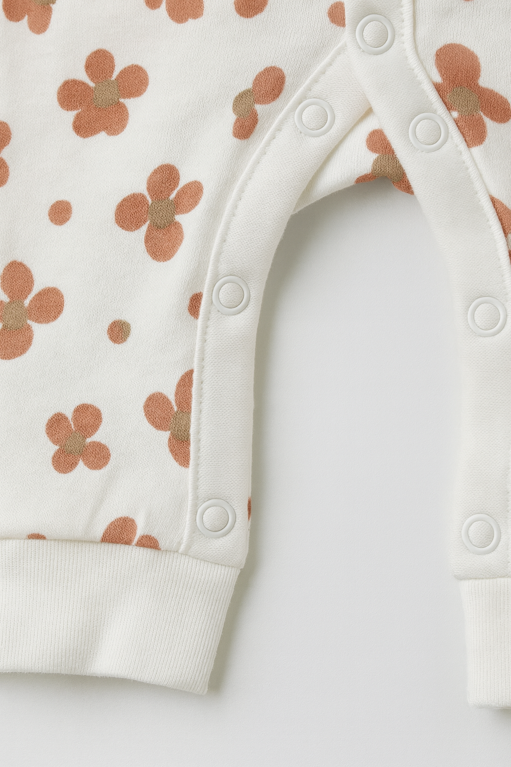 Baby romper with floral pattern and 'Hello World' text on a light gray background