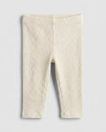 Baby girls' cream cable-knit leggings with wide elasticated waistband, flat lay
