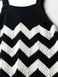 Black and white chevron patterned sweater on a plain background