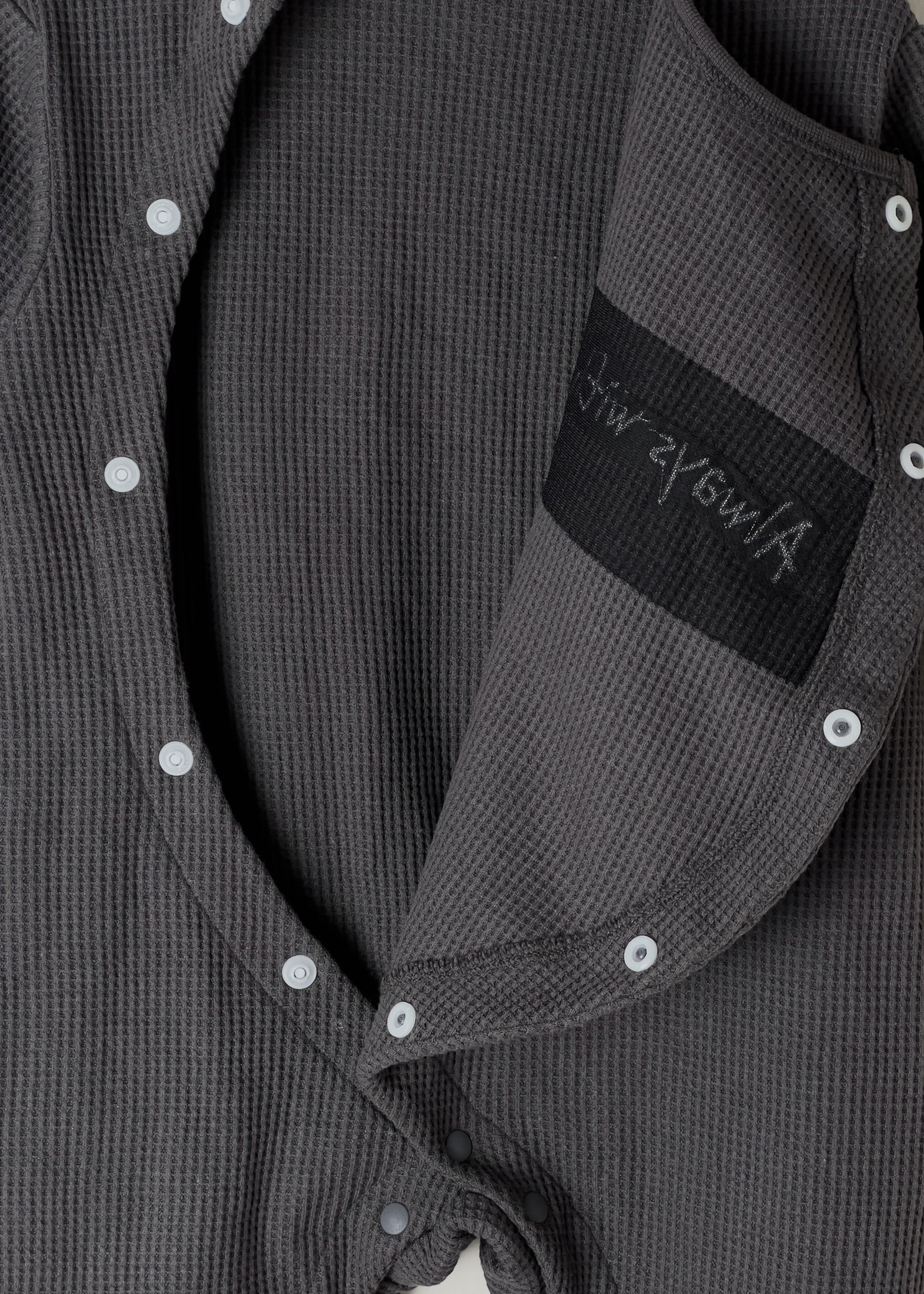 Black baby romper with 'Always with a smile' text on a light gray background