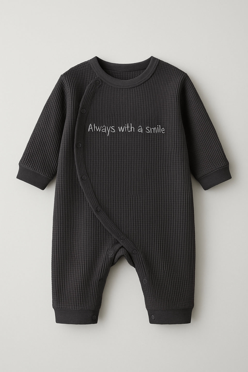 Black baby romper with 'Always with a smile' text on a light gray background