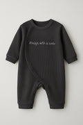 Black baby romper with 'Always with a smile' text on a light gray background
