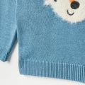 Blue knitted sweater with a bear face design on a white background
