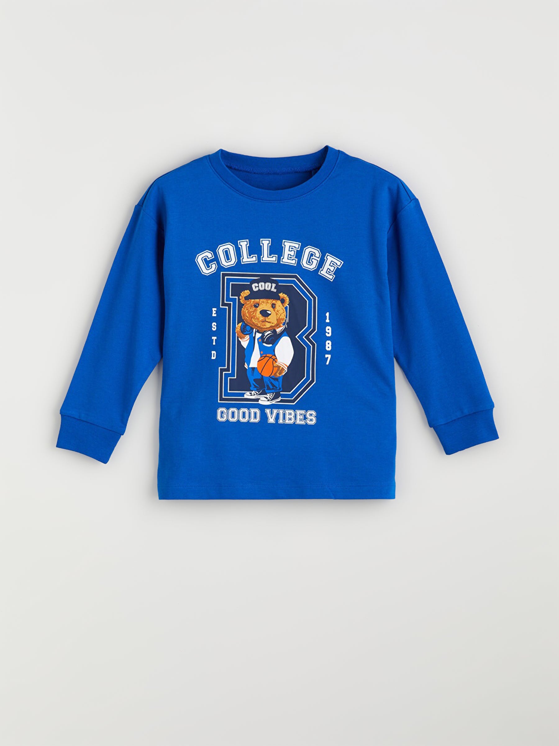 Blue long-sleeve shirt with bear graphic and text on a light grey background