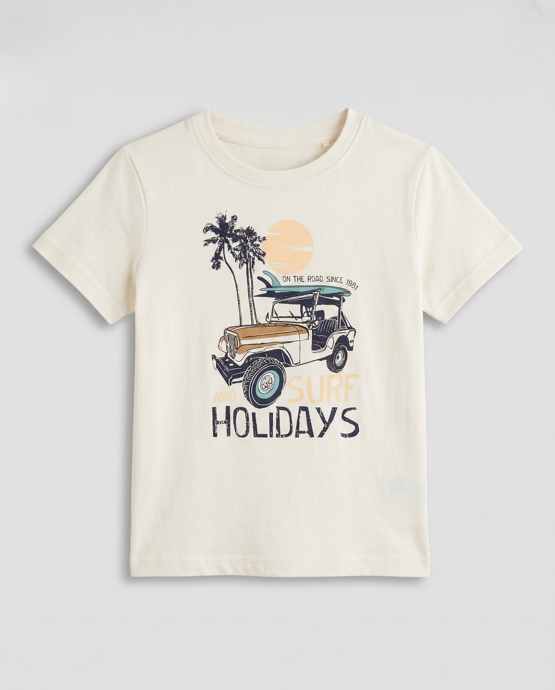  Boys' off white half sleeve cotton t-shirt with surf and holidays adventure graphic, flat lay product photo on light grey background.