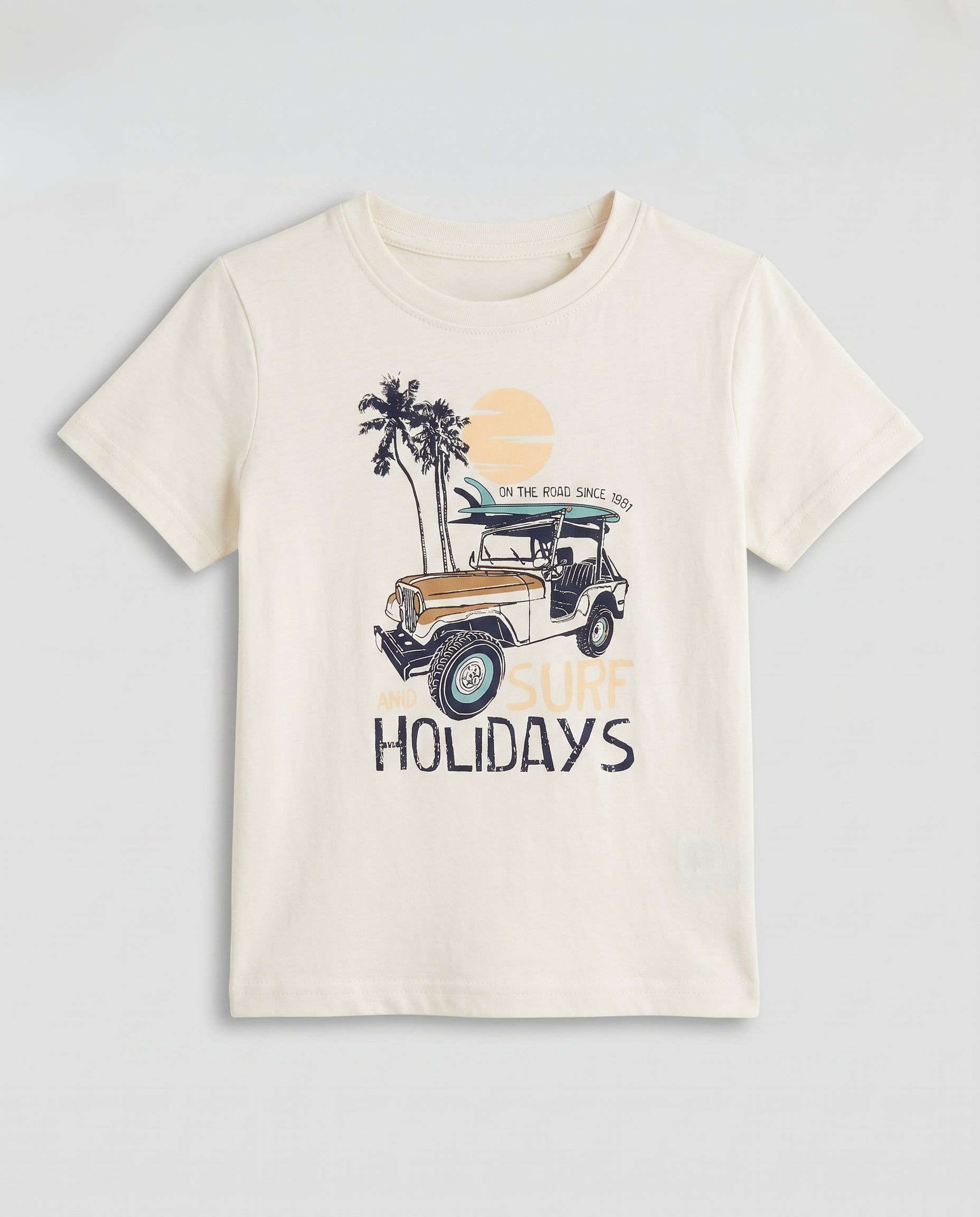  Boys' off white half sleeve cotton t-shirt with surf and holidays adventure graphic, flat lay product photo on light grey background.