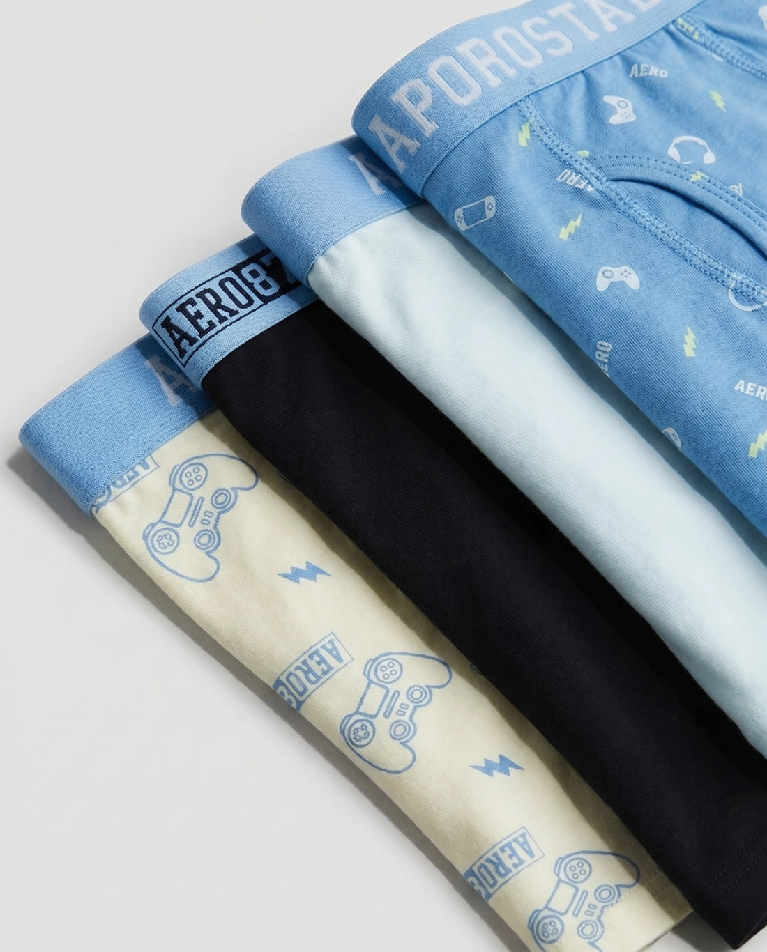 Pack of 4 boys' premium cotton boxer briefs in sky blue gamer print, lime cream controller print, solid black, and powder mint, fanned out flat lay