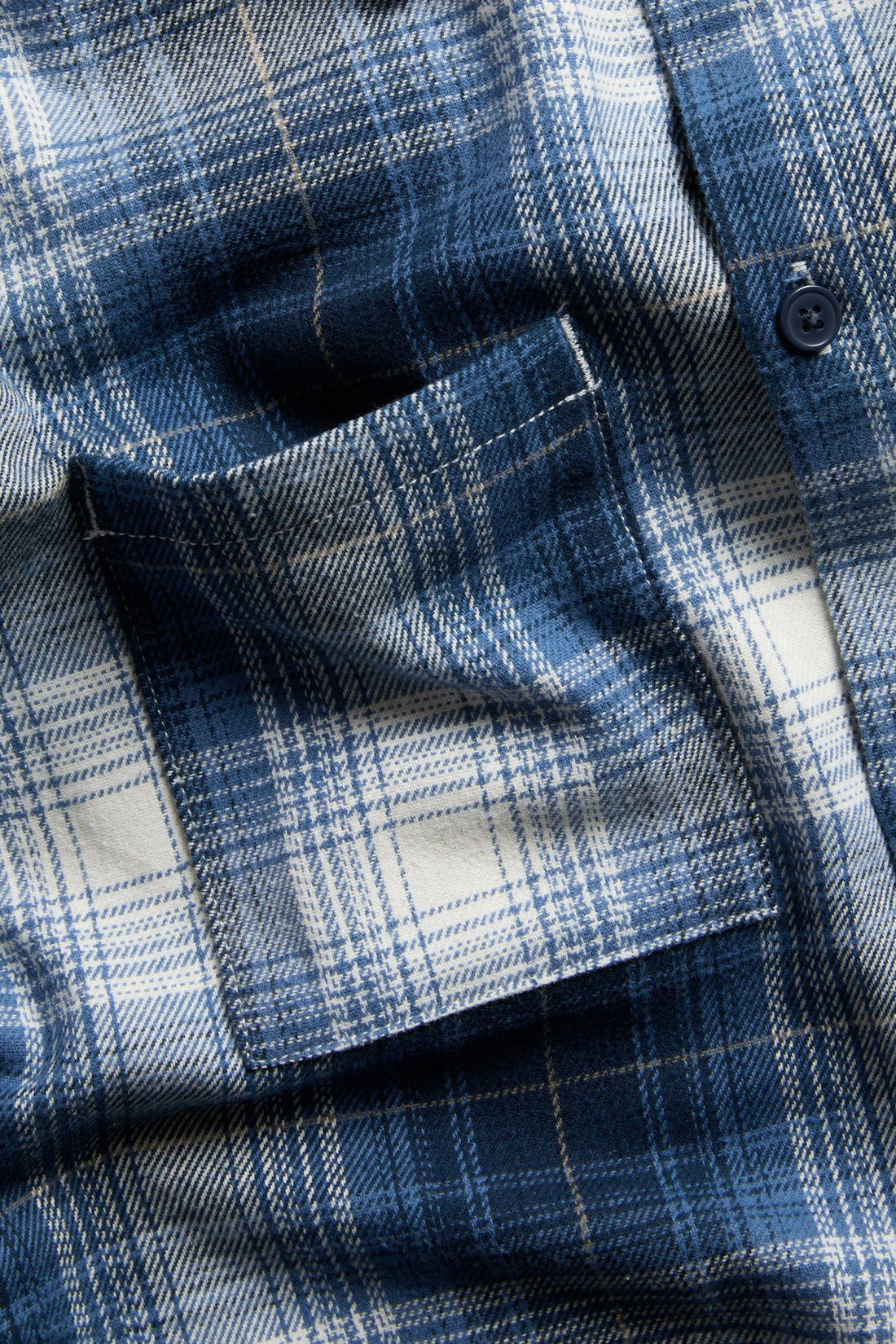 PTex Fashion boys' blue and off-white flannel check overshirt close-up showing brushed twill texture, contrast-stitched patch pocket and navy button