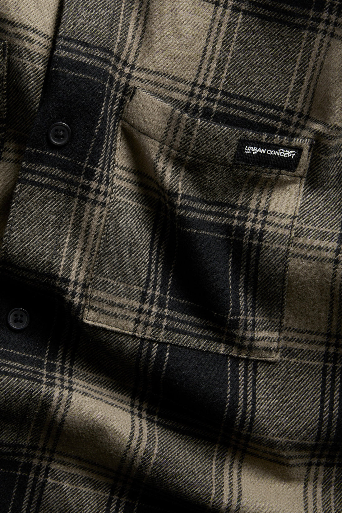 PTex Fashion boys' taupe and black flannel check overshirt close-up showing brushed twill texture, patch pocket with woven label and black buttons
