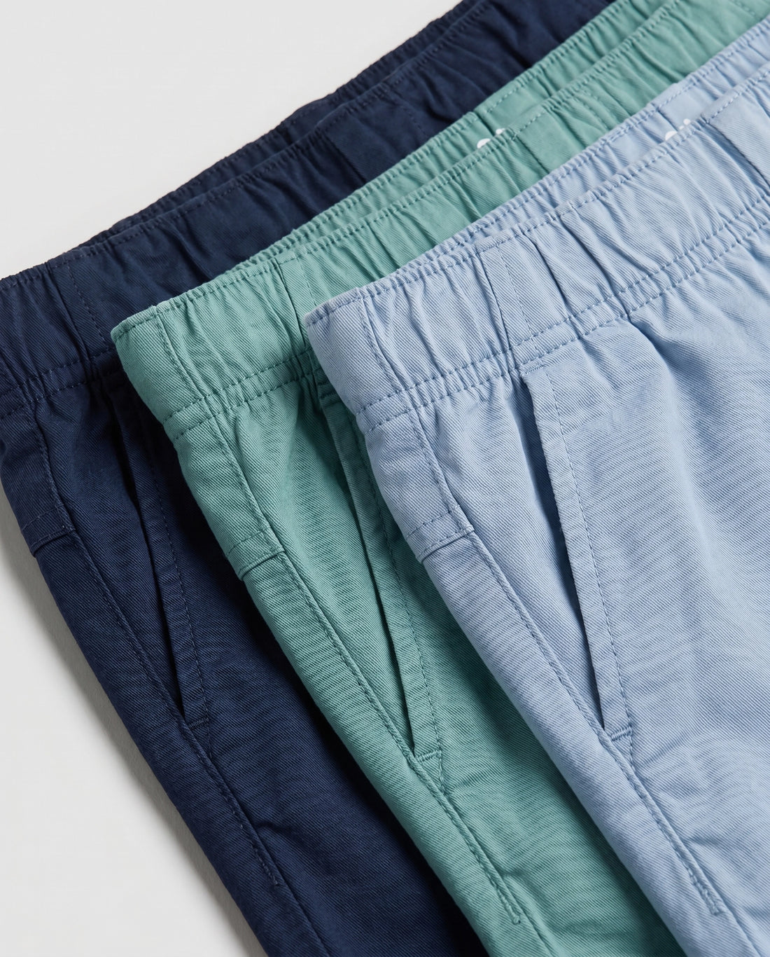 Boys' navy blue pull-on chino shorts, flat lay front view showing fully elasticated waistband, slant side pockets, and relaxed straight-leg fit