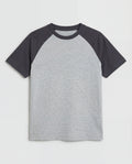 Boys' short-sleeve raglan cotton t-shirt laid flat, featuring a heather grey body with contrast charcoal raglan sleeves and a ribbed crew neckline.