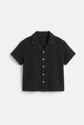 Boys black muslin short sleeve shirt with textured fabric, camp collar and button front