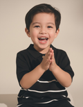 Child clapping hands against a plain background