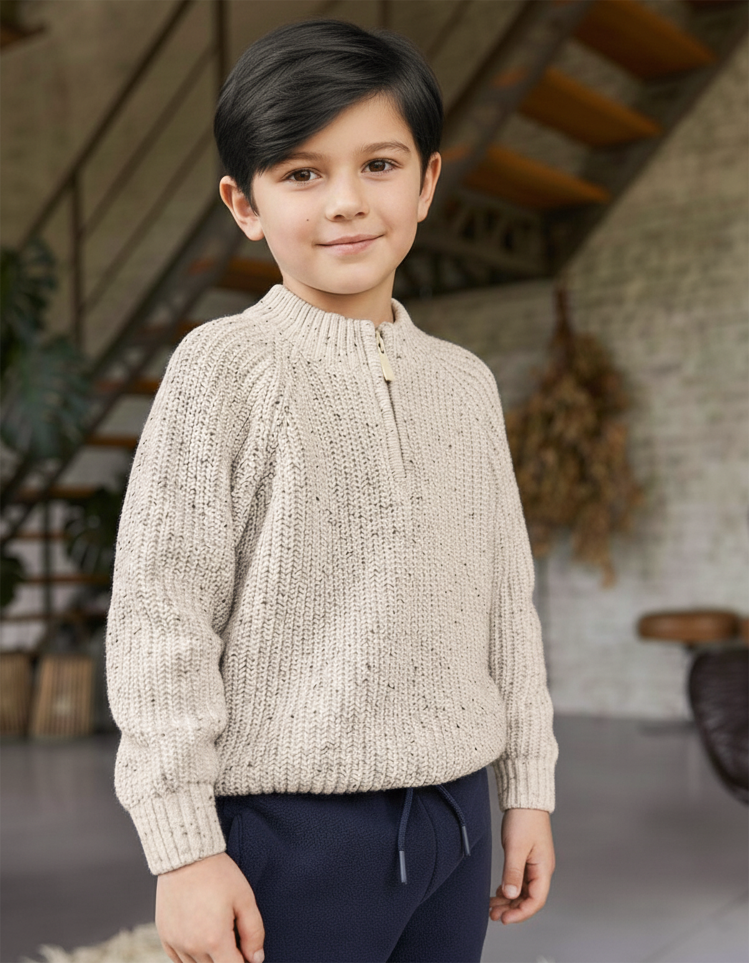 Child wearing a beige knitted sweater in an indoor setting