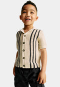 Child wearing a knitted striped patterned polo on a plain background