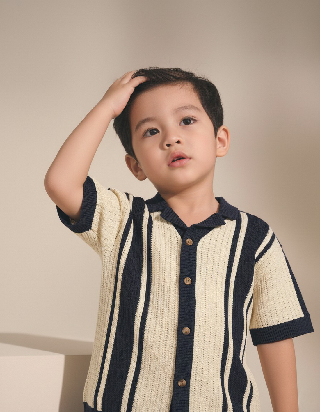 Child wearing a striped shirt with a neutral background
