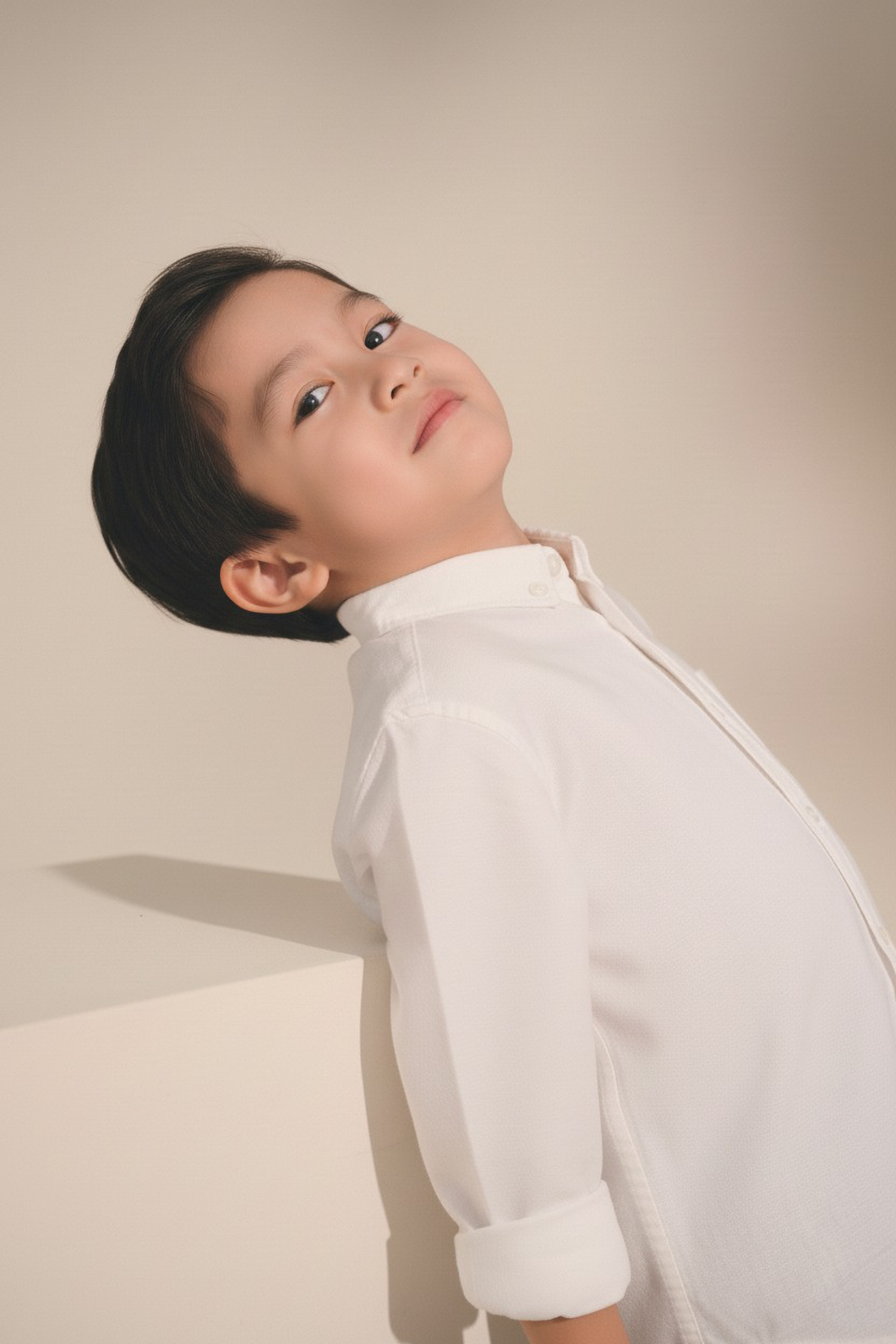 Child wearing a white shirt against a plain background