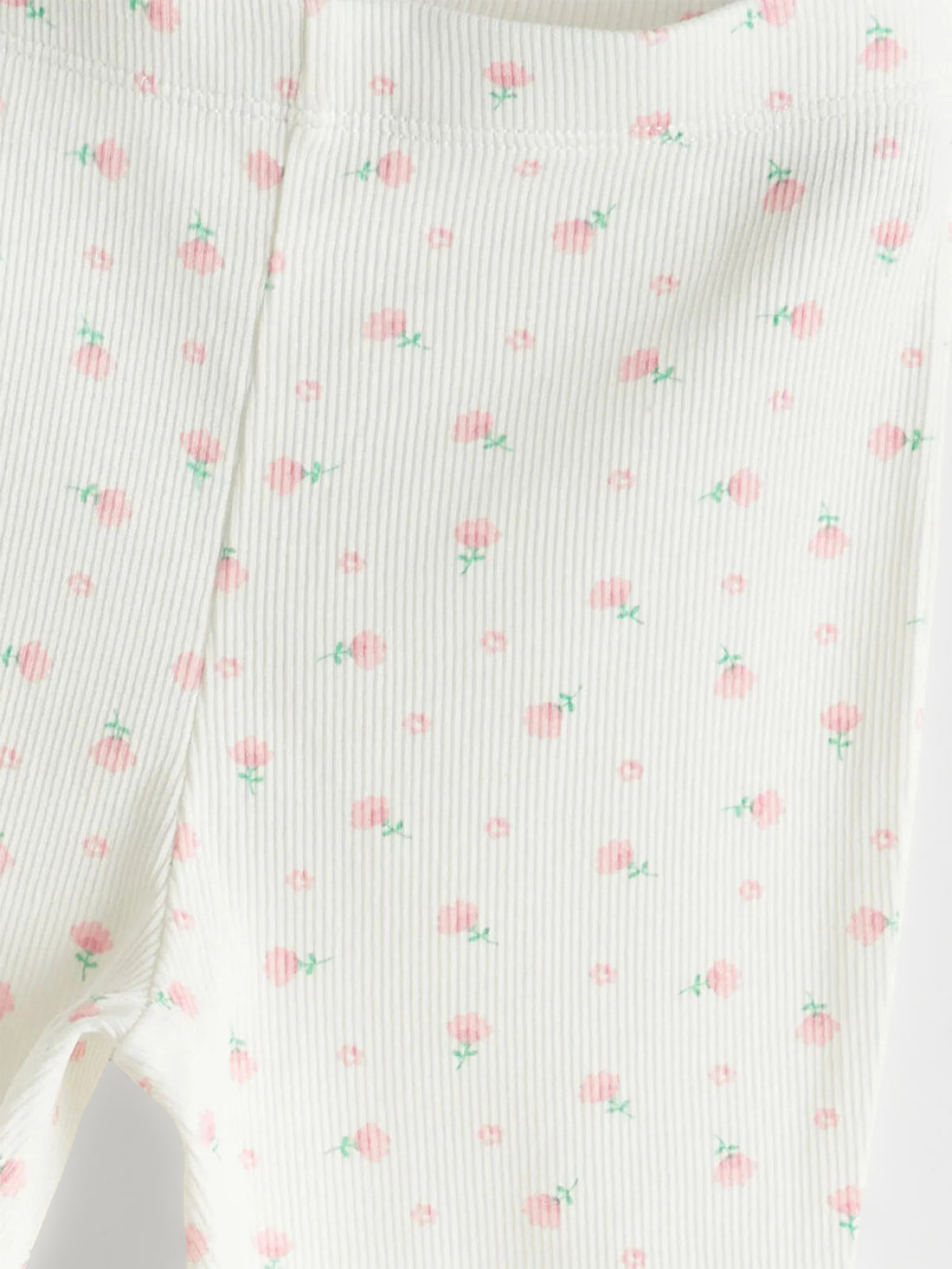 White leggings with small pink patterns on a light gray background