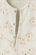 Close-up of a baby outfit with bear pattern and buttons on a light background