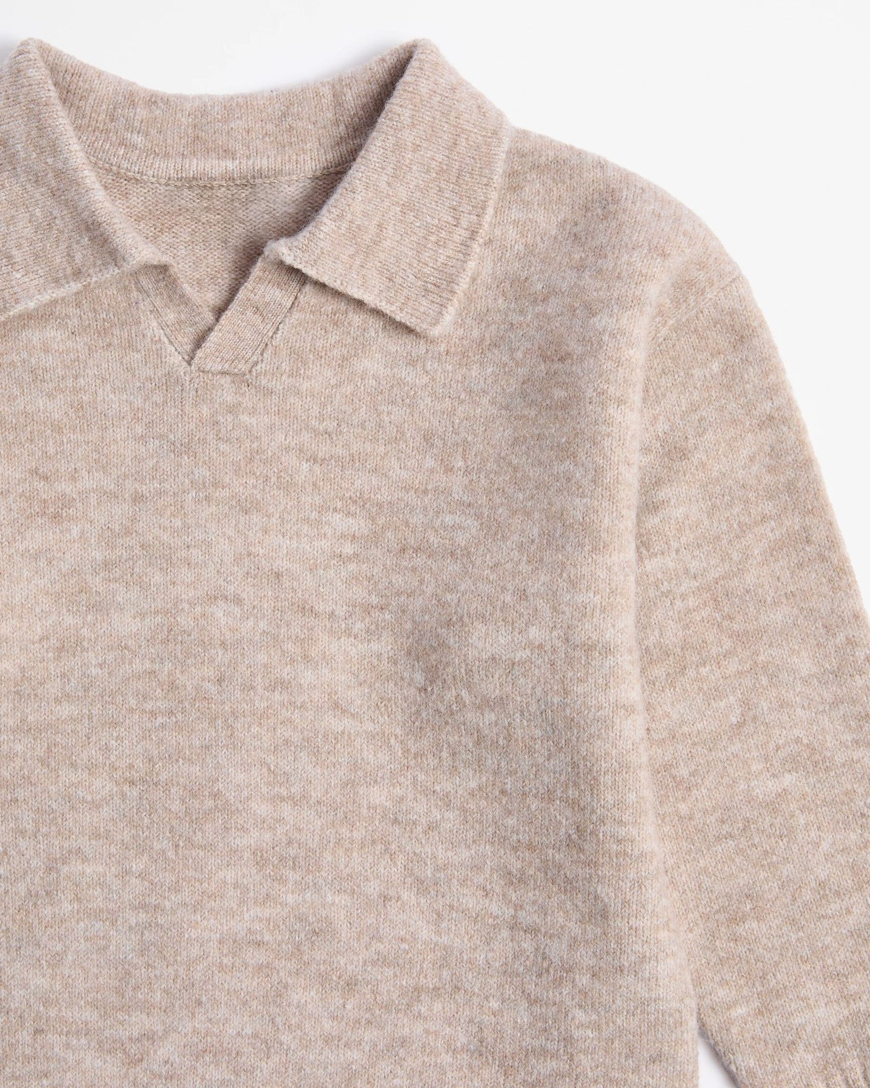 Close-up of a beige kids sweater with a collar on a white background