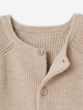 Close-up of a beige knitted cardigan with buttons on a light background