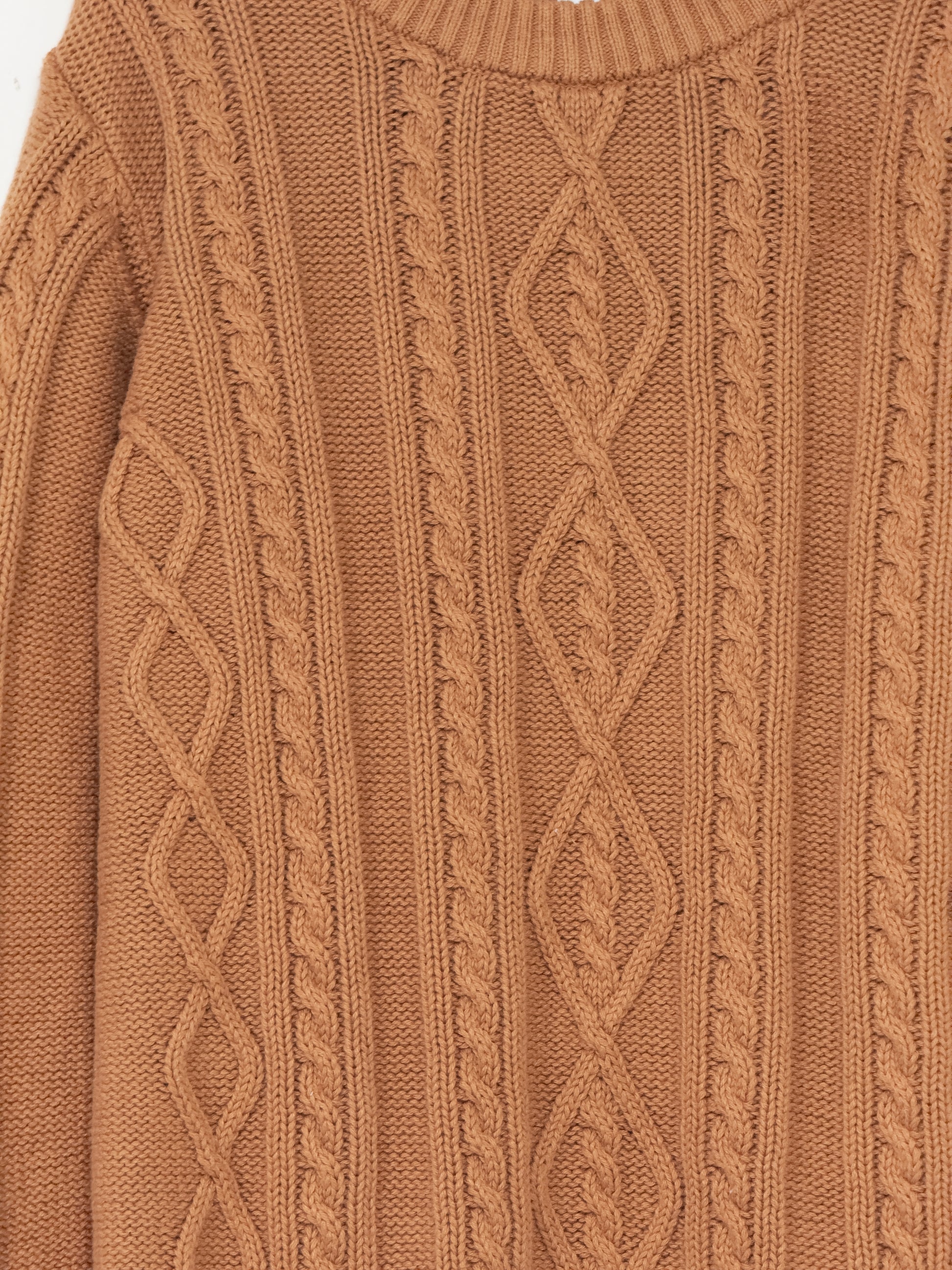 Close-up of a caramel colour cable knit sweater