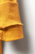 Close-up of a mustard yellow textured fabric on a plain background