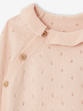 Close-up of a pink knitted cardigan with button details on a white background