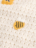 Close-up of a textured fabric surface with embroidered bee designs.