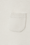 Close-up of a textured white fabric with a pocket detail