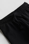Close-up of black pants on a light gray background