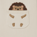 Embroidered hedgehog design on a textured beige fabric