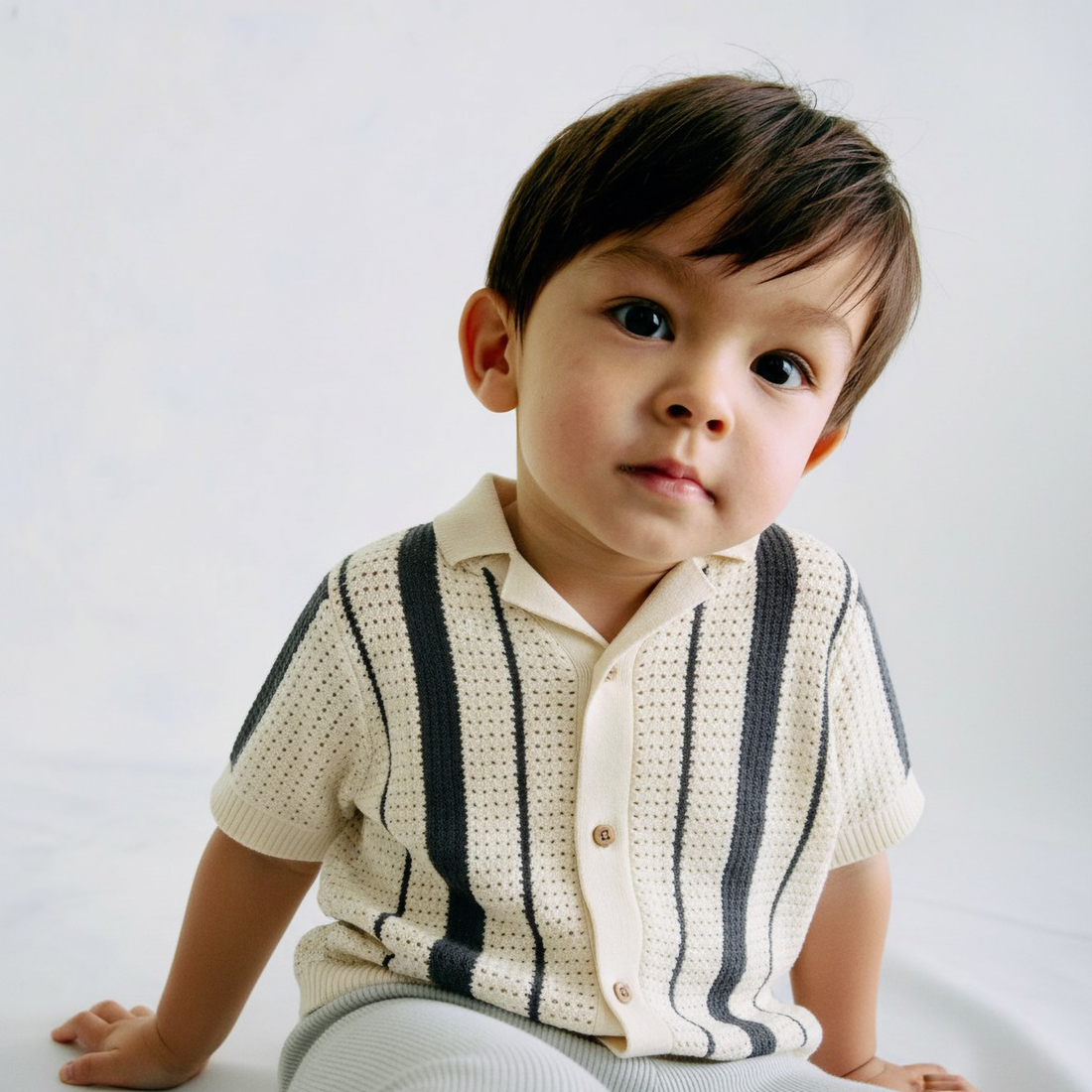 Beige short-sleeve shirt with black stripes on a light gray background