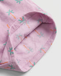 Close-up of lilac palm tree print cotton fabric showing matching soft printed cotton inner lining and overlock stitch hem detail of girl's short pant
