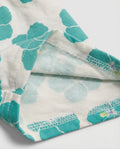 Close-up of white and teal hibiscus print cotton fabric showing soft brushed cotton terry inner lining and overlock stitch finishing detail