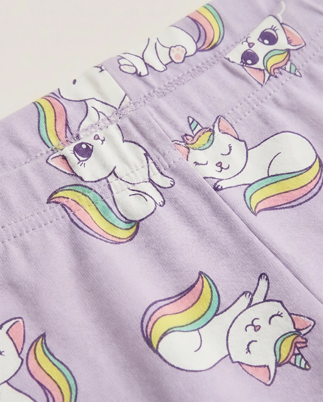 Full-length girls' lavender stretch leggings with all-over unicorn cat and rainbow print, elasticated waistband, slim fit design, laid flat on a white background.